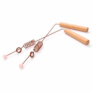 May include: Two dowsing rods with wooden handles and copper wire components. Each rod features a copper coil and a pink gemstone at the tip. The rods are designed for divination and spiritual practices.