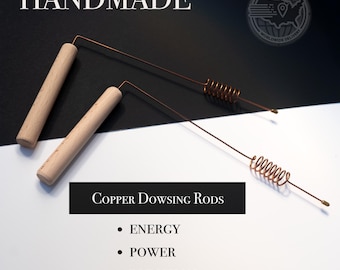 May include: Two copper dowsing rods with wooden handles. The rods are bent at a 90-degree angle and have a coil of copper wire at the end. The text "HANDMADE" is at the top of the image. The text "COPPER DOWSING RODS" is below the rods. The text "ENERGY", "POWER", and "PRECISION" are listed below the text "COPPER DOWSING RODS".