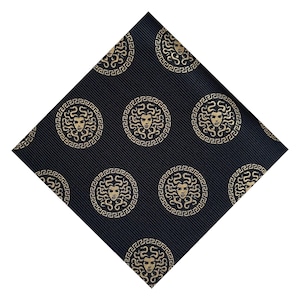 Könnte beinhalten: Schwarzes Einstecktuch mit einem sich wiederholenden goldenen Medusa-Kopf-Muster. Das kreisförmige Design befindet sich auf einem schwarzen Hintergrund mit dezenten diagonalen Streifen. Ein stilvolles Accessoire.