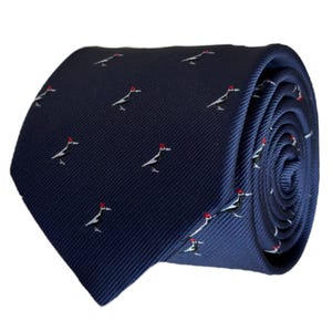 May include: A dark blue silk tie with a repeating pattern of white birds wearing red hats.