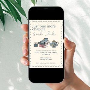 May include: A smartphone displaying a book club invitation with the text "Just one more chapter Book Club" and details for a meeting on November 20, 2024 at 4:00 PM. The invitation features illustrations of a teapot, books, and a candle.