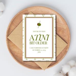 May include: A green and white birthday party invitation with a martini glass and olive illustration. The text reads "You're invited to a  tini bit older, Cara's Birthday Party, October 23, 2024, 7PM".