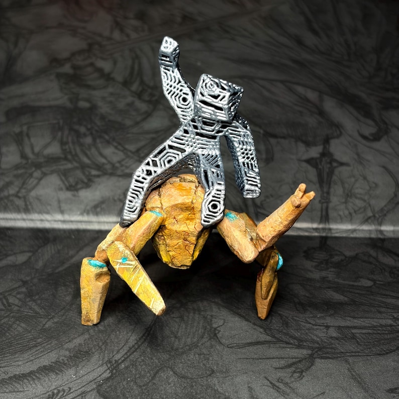 May include: A detailed sculpture of a figure atop a multi-legged creature. The figure is silver, with an open, geometric design. The creature is primarily tan with blue accents. The artwork is set against a dark, patterned background.