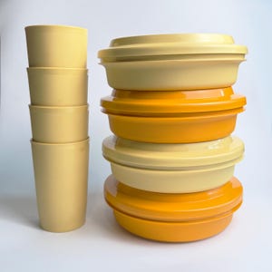 Peut inclure: Ensemble de vaisselle vintage dans les tons jaune et orange. L'ensemble comprend plusieurs tasses cylindriques et une pile de récipients ronds avec couvercles. Les récipients sont de différentes nuances de jaune et d'orange.