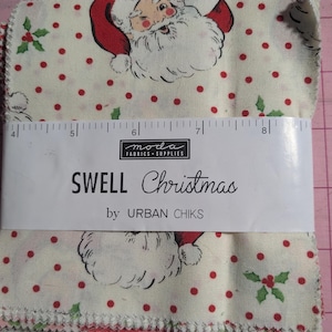 May include: A stack of fabric squares featuring a cream background with red polka dots, green holly leaves, and Santa Claus illustrations. A white paper band displays the text MODA FABRICS + SUPPLIES, SWELL Christmas by URBAN CHIKS, and a ruler measuring 4 to 8 inches.