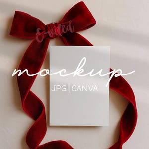 May include: A white rectangular mockup card with the word "mockup" in cursive script, and the text "JPG | CANVA". A deep red velvet ribbon is arranged around the card in a bow shape.
