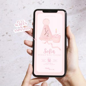 May include: A pink and white digital invitation for a half birthday party. The invitation features a pink cupcake with a single candle and a pink party hat with the number 1/2 on it. The text on the invitation reads "Sofia is half way to one!" and includes the date and time of the party.