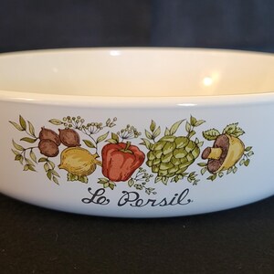 Może przedstawiać: Biała ceramiczna forma do pieczenia z zielonym, brązowym i czerwonym wzorem kwiatowym przedstawiającym warzywa i tekst "Le Persil".