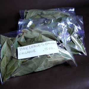 K&ouml;nnte beinhalten: Drei durchsichtige Plastikt&uuml;ten gef&uuml;llt mit getrockneten Lorbeerbl&auml;ttern, beschriftet mit "BAY LEAVES (LAUREL) ORGANIC .5 OZ."