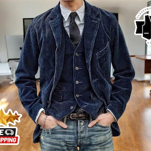 Op de afbeelding: Een blauwe corduroy blazer met een bijpassend vest en een donkerblauwe stropdas. De blazer heeft een enkele knoopsluiting en twee klepzakken. Het vest heeft een knoopsluiting en vijf knopen. De stropdas is effen en heeft een puntige punt.