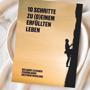 May include: A motivational poster with a silhouette of a person rock climbing a cliff. The poster has a sunset background and the text "10 SCHRITTE ZU (D)EINEM ERF&Uuml;LLTEN LEBEN DER GUIDE ZU DEINER PERS&Ouml;NLICHEN WEITERENTWICKLUNG".