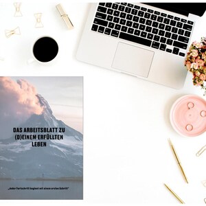 May include: A motivational worksheet with a mountain range background. The text reads "Das Arbeitsblatt zu (D)einem Erf&uuml;llten Leben" and "Jeder Fortschritt beginnt mit einem ersten Schritt".
