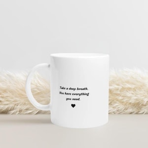 May include: White ceramic mug with a black inspirational quote that reads "Take a deep breath. You have everything you need." and a small black heart.