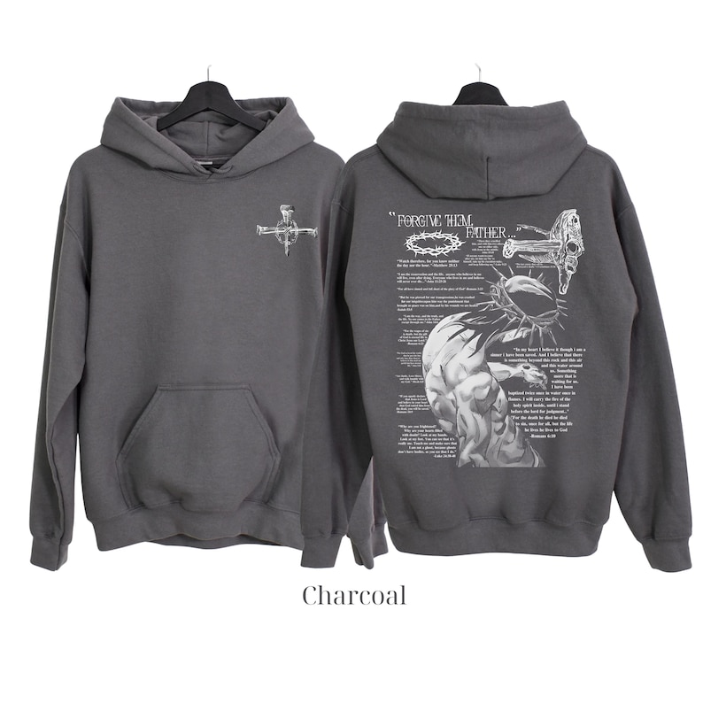 May include: Charcoal gray hoodie with a front pocket and hood. The front features a small cross design. The back displays a detailed graphic with the text "FORGIVE THEM FATHER" and a depiction of a crown of thorns and a figure.