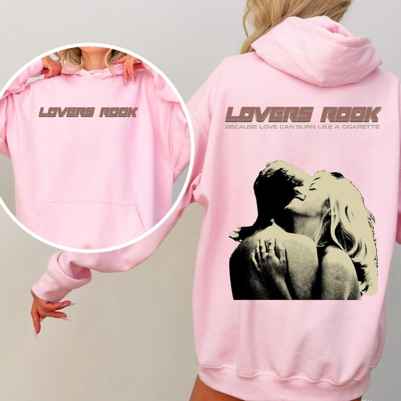 May include: Pink hoodie with a graphic print of a couple embracing. The text "Lovers Rock" is printed on the front and back of the hoodie. The text on the back also says "Because love can burn like a cigarette."