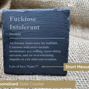 Könnte beinhalten: Ein personalisierter Schieferuntersetzer mit der Definition von "Fucktose Intolerant" in Weiß graviert. Die Definition umfasst Indikatoren wie Augenrollen und Sarkasmus. Der Untersetzer hat auch den Text "Lots of love Name??" und "Short Message?"