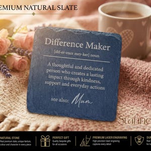 May include: A square dark gray natural slate coaster featuring white laser-engraved text that reads Difference Maker, a phonetic pronunciation, a definition of the noun, and the phrase see also: Mum in a cursive script font.