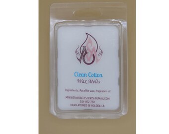 May include: A clear plastic package containing a white wax melt with the scent "Clean Cotton". The package has a pink and purple logo with the text "Wax Melts" and contact information for the seller.