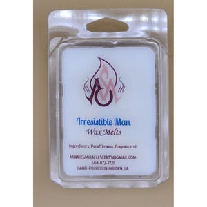 May include: A white wax melt product in a clear plastic package. The label reads "Irresistible Man Wax Melts" with a flame logo and the initials "A" and "M". Ingredients include paraffin wax and fragrance oil.