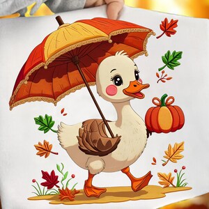 Puede incluir: Un lienzo blanco con un pato de dibujos animados sosteniendo un paraguas rojo y amarillo y una calabaza. El pato tiene patas y pico naranjas, con mejillas rosadas. Hojas de otoño y una calabaza están esparcidas alrededor del pato.