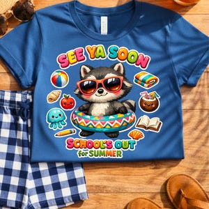 May include: Blue t-shirt with a raccoon graphic wearing sunglasses and a swim ring. The shirt has the text "SEE YA SOON" and "SCHOOL'S OUT for SUMMER". Beside the shirt are blue and white checkered shorts, sandals, and a straw hat.