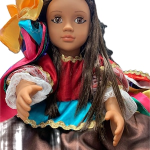 May include: A doll with brown hair and brown eyes, wearing a colorful dress. The dress features red, blue, and brown fabric with gold trim and white lace. A large, multi-colored bow adorns the doll's hair. The doll's skin tone is light brown.