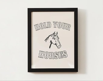 May include: Black and white framed print with the text "HOLD YOUR HORSES" in a stylized font. A black and white illustration of a horse's head is centered below the text.
