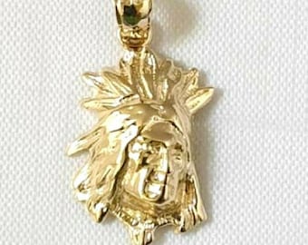 May include: Gold-toned pendant featuring a detailed depiction of a Native American chief wearing a headdress. The pendant is a traditional design and would make a great addition to any jewelry collection.