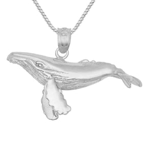 Puede incluir: Un collar con un colgante de plata en forma de ballena. La ballena está representada de forma realista, con aletas detalladas y un cuerpo texturizado. El collar está hecho de una delicada cadena de plata.