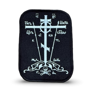May include: Black rectangular patch with a white Orthodox cross design. The cross is centered and features Cyrillic text and a skull and crossbones at the bottom. The patch has a stitched border.