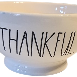 Puede incluir: Cuenco de cerámica blanca con la palabra "THANKFUL" en letras negras manuscritas. El cuenco tiene forma redondeada con un borde ligeramente ensanchado y una pequeña base elevada. Ideal para servir o como pieza decorativa.