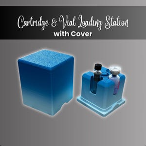 May include: A blue gradient cartridge and vial loading station with cover. The text Cartridge & Vial Loading Station with Cover is displayed above. The base features molded slots holding one clear glass vial and one small glass cartridge.