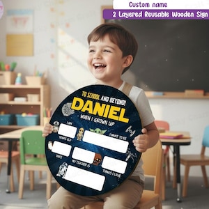 May include: A round, two-layered wooden sign with a dark blue space-themed background featuring Star Wars characters. The text reads TO SCHOOL AND BEYOND, DANIEL, WHEN I GROWN UP, I AM, YEARS OLD, I WANT TO BE, DATE, MY TEACHER IS, and THINGS I LOVE.