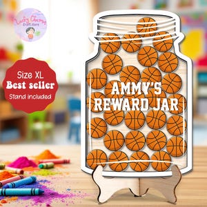 May include: A wooden reward jar shaped like a mason jar, filled with basketballs. The jar reads "AMMY'S REWARD JAR" in white text. The jar is on a wooden stand. A red sign says "Size XL Best seller Stand included".
