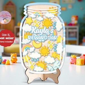 Pode incluir: Um frasco de recompensa de madeira em forma de frasco, com uma borda azul clara e um suporte de madeira. O frasco é decorado com sóis, estrelas, arco-íris e nuvens coloridas. O texto "Kayla's REWARD JAR" é exibido em azul claro.