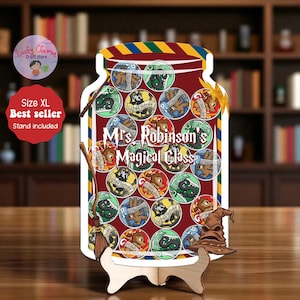 Könnte beinhalten: Dekoratives Holzschild in Form eines Glases, mit kreisförmigen Bildern mit Wappen und dem Text "Mrs. Robinson's Magical Class". Enthält einen Holzständer, einen Besen und einen Hut. Das Schild ist rot mit einem gestreiften Oberteil.