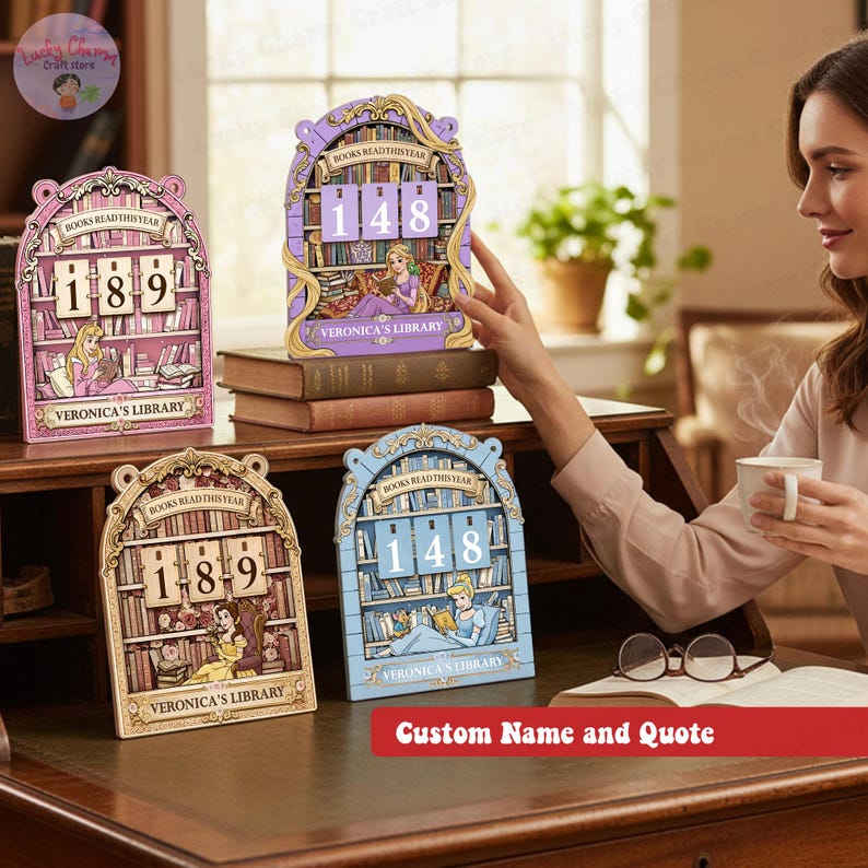 May include: Decorative wooden book-themed calendar with the text "BOOKS READ THIS YEAR" and a custom name. The calendar features a princess reading a book, with the numbers 189 and 148 displayed. Available in pink, gold, and blue.