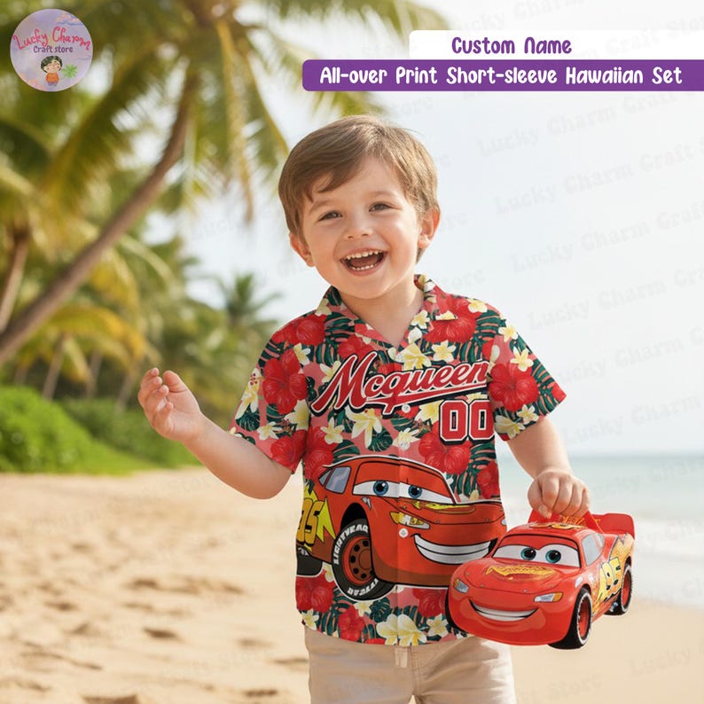 May include: A child's red Hawaiian shirt with a floral design and a Lightning McQueen graphic. The shirt features short sleeves and the text "McQueen 00". The child is holding a red Lightning McQueen toy car.