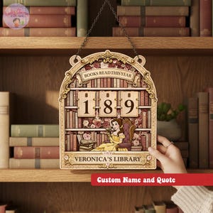 May include: Wooden wall hanging with a library theme. The sign features a decorative frame with the words "BOOKS READ THIS YEAR" at the top. The center displays the numbers "189" and a cartoon of a woman in a yellow dress. The sign reads "VERONICA'S LIBRARY".