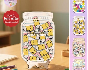 以下が含まれることがあります： 鉛筆をテーマにした木製の瓶型サイン。「Mrs. Smith's class is ALWAYS SHARP」と書かれており、ピンクの消しゴムが付いた黄色の鉛筆が描かれています。サインは木製のスタンドに表示されています。さまざまなデザインの追加の瓶型サインも表示されています。