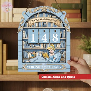 May include: A light blue wooden bookshelf-shaped sign with the text "BOOKS READ THIS YEAR" and the number "148". The sign features a Cinderella illustration reading a book, with the text "VERONICA'S LIBRARY" below. A red banner at the bottom says "Custom Name and Quote".
