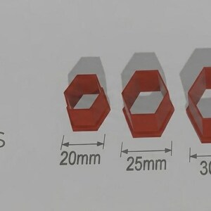 May include: Five red hexagon-shaped polymer clay cutters, sized from 20mm to 40mm. The cutters are presented against a light grey backdrop, with the "Pampa Cutters" logo visible.