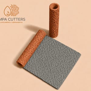 Puede incluir: Un rodillo de arcilla color terracota y una esterilla de arcilla gris texturizada con un patrón geométrico. Un segundo rodillo de terracota está de pie. El logotipo "PAMPA CUTTERS" es visible en la esquina superior izquierda.