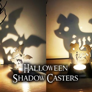 May include: Halloween-themed shadow casters. The image features a carved pumpkin, a decorative tree, and wooden cutouts of bats and a dog, casting spooky shadows. The text "Halloween Shadow Casters" is displayed.
