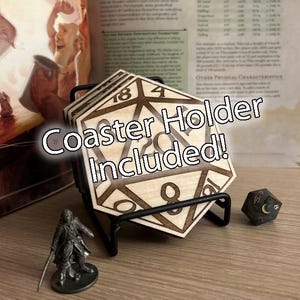 May include: Wooden D20-shaped coasters with etched numbers, stacked in a black metal holder. A miniature figurine and a D&D die are next to the coasters. The text "Coaster Holder Included!" is on the coasters.