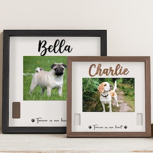 May include: Two framed pet portraits, one black and one brown, each with a photo of a dog. The black frame has the name "Bella" above the photo, and the brown frame has the name "Charlie". Both frames have the text "Forever in our heart".