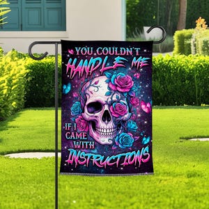 Könnte beinhalten: Eine rechteckige Gartenflagge mit einem zentralen menschlichen Schädel, der mit leuchtend rosa und blauen Rosen verziert ist. Der Hintergrund ist ein dunkles, sternenreiches Galaxienmuster. Der Text lautet: YOU COULDN'T HANDLE ME IF I CAME WITH INSTRUCTIONS.