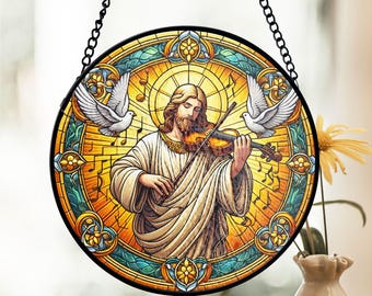 Puede incluir: Una ventana de vitral colgante con una representación de Jesús tocando el violín con dos palomas blancas a cada lado. El fondo es un diseño de vitral colorido con notas musicales.