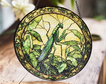 Vitral colgante con diseño de mantis religiosa: una obra de arte detallada inspirada en la naturaleza con hojas verdes.