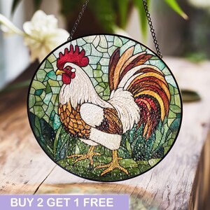 May include: A stained glass window hanging with a colorful rooster design. The rooster is white with brown and red accents. The background is green with a mosaic pattern.
